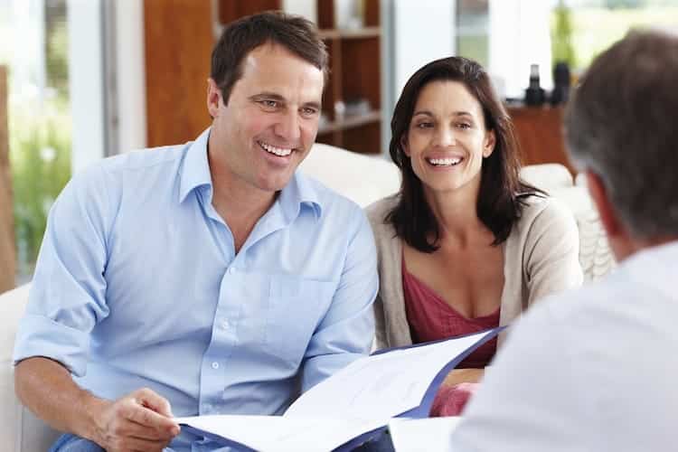 Smiling couple taking financial advice from consultant at home